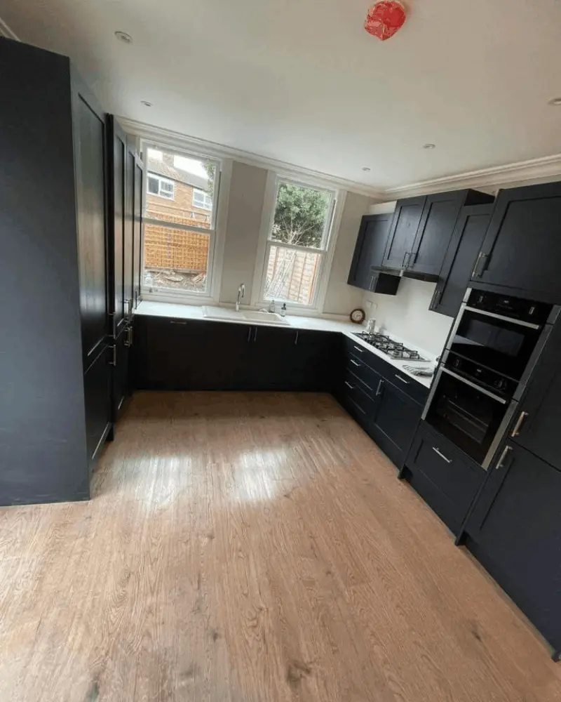 Modern kitchen installation with dark cabinets and wooden flooring in Berkshire