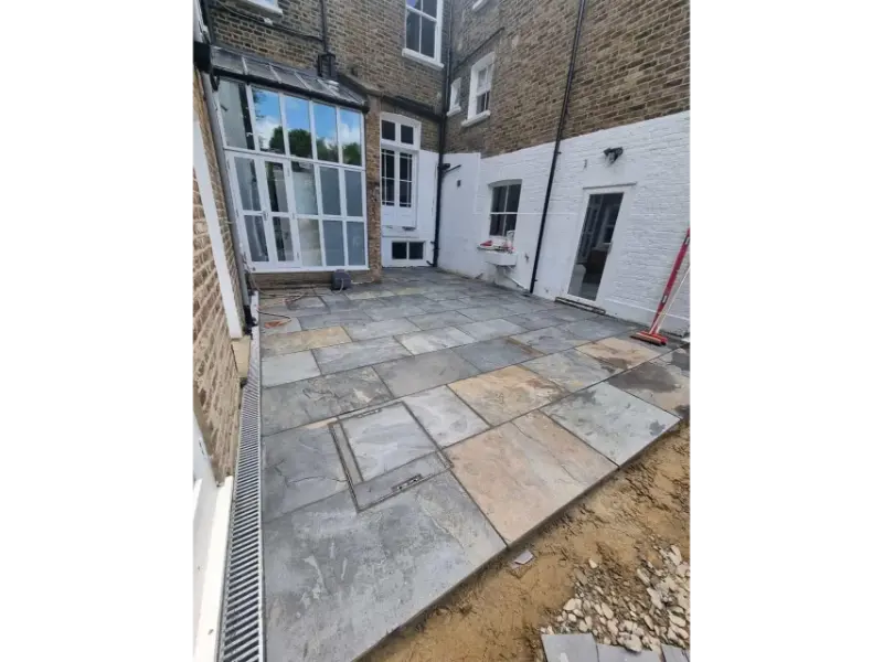 Finished natural stone patio at Victorian townhouse in Shepherd’s Bush London with clean modern layout
